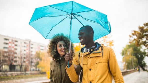 Young couple walking with an umbrella
