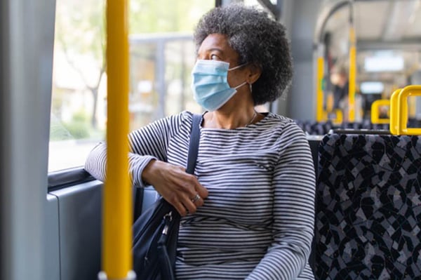 Woman on a bus wearing a mask